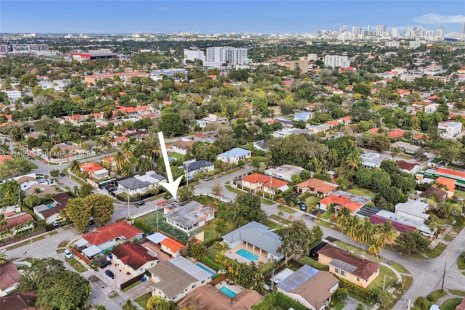 500 SW 39th Court, Miami, FL 33134 Aerial perspective of a corner lot residence featuring a screened-in rear patio, mature landscaping, and a fenced yard