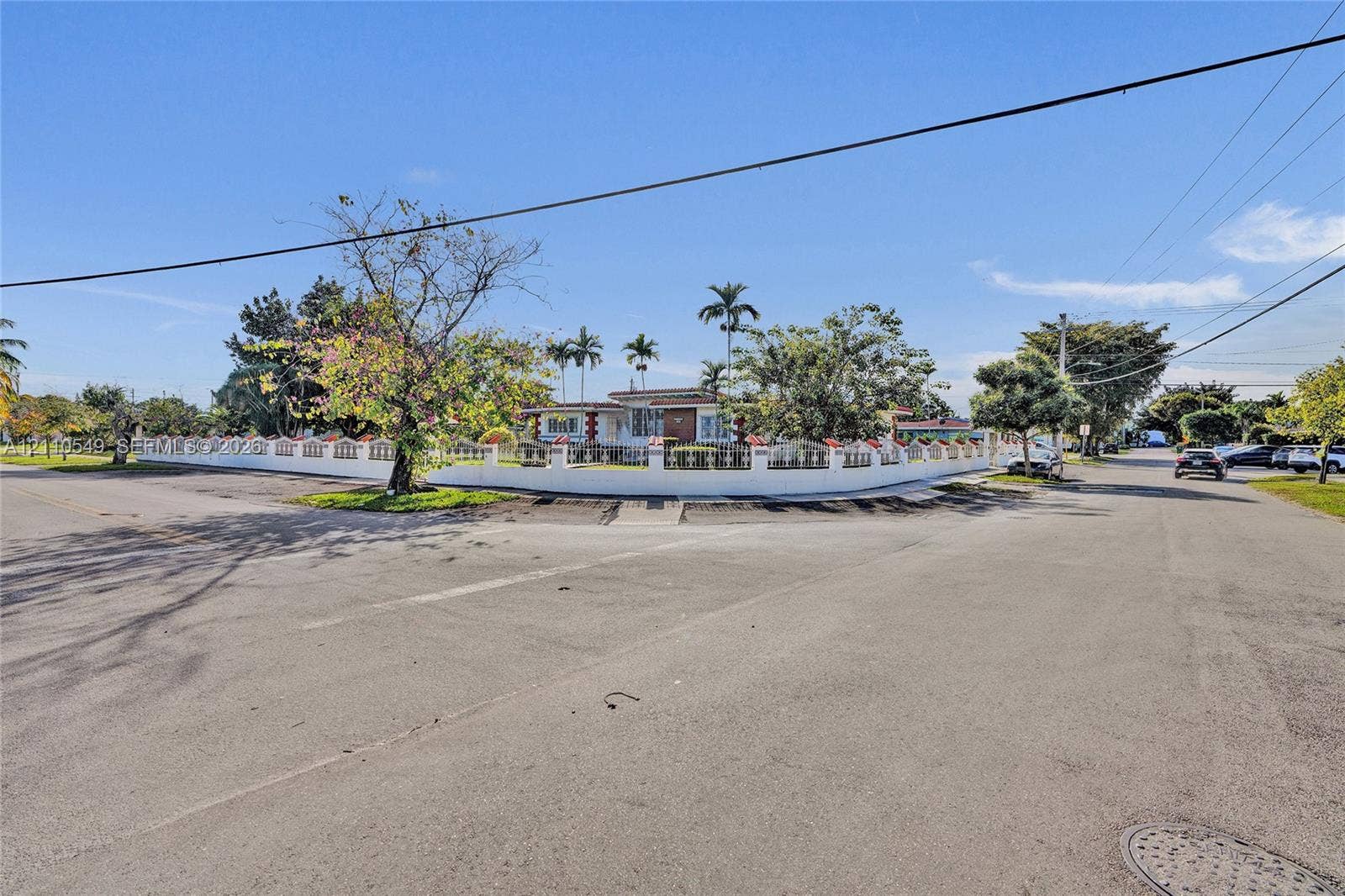 500 SW 39th Court, Miami, FL 33134 Corner lot property featuring a masonry perimeter wall, integrated metal fencing, and mature landscaping