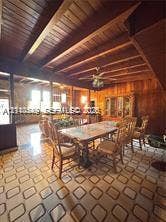 500 SW 39th Court, Miami, FL 33134 Exposed wood beam ceiling, wood paneled walls, patterned tile flooring, and a ceiling fan with integrated lighting