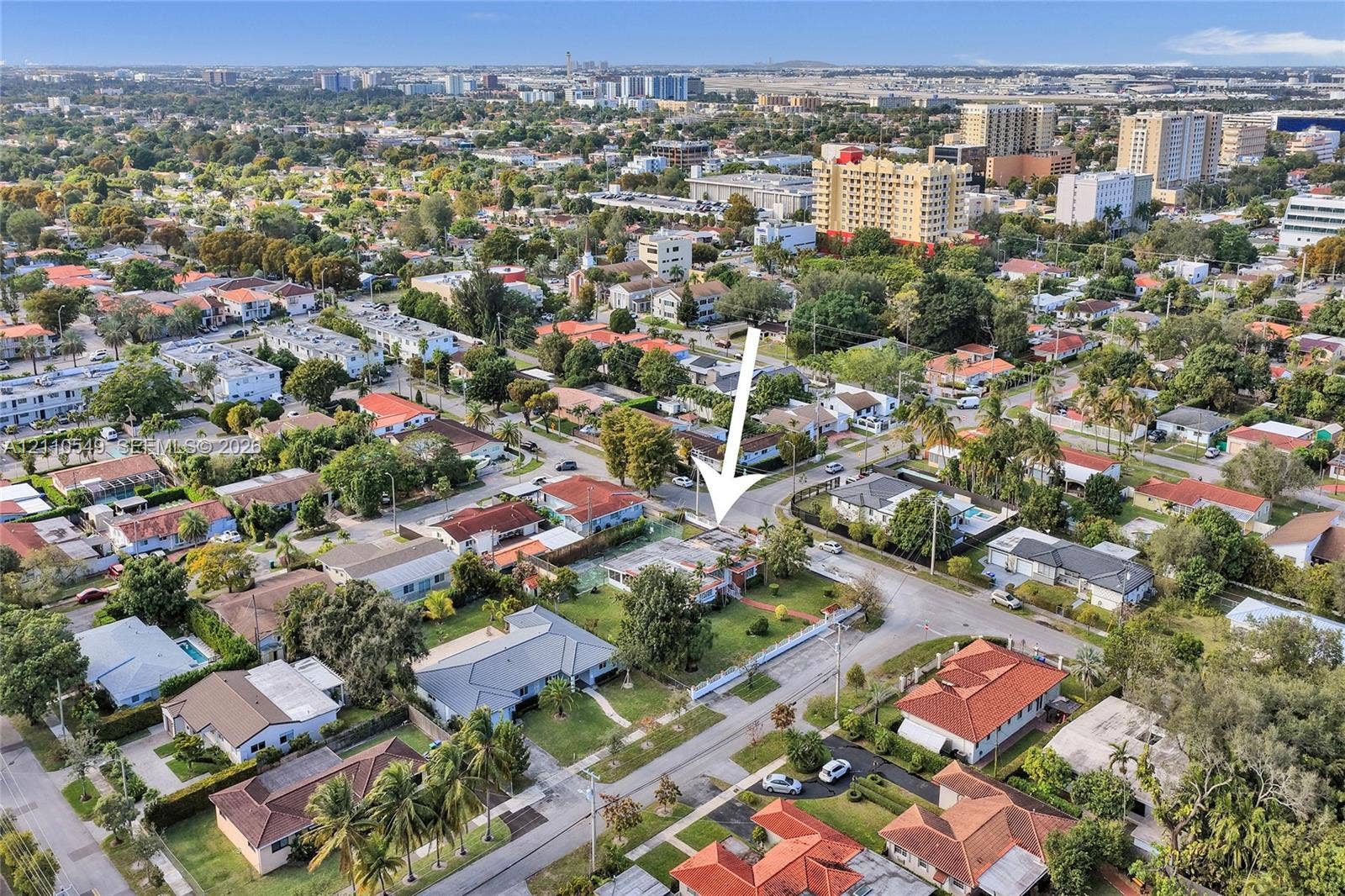 500 SW 39th Court, Miami, FL 33134 Aerial perspective of a residential property featuring a corner lot, mature landscaping, fenced perimeter, and driveway