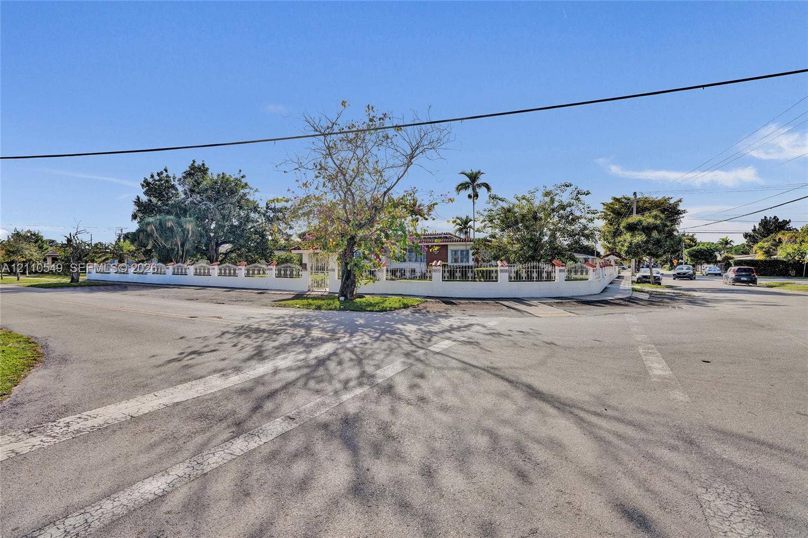 500 SW 39th Court, Miami, FL 33134 Corner lot property featuring a perimeter masonry wall with decorative accents, mature landscaping, and established trees