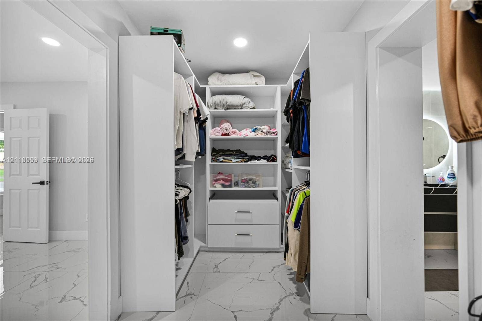 16611 SW 108th Court, Miami, FL 33157 Walk-in closet featuring custom white built-in shelving, integrated dresser drawers, recessed lighting, and large-format tile flooring