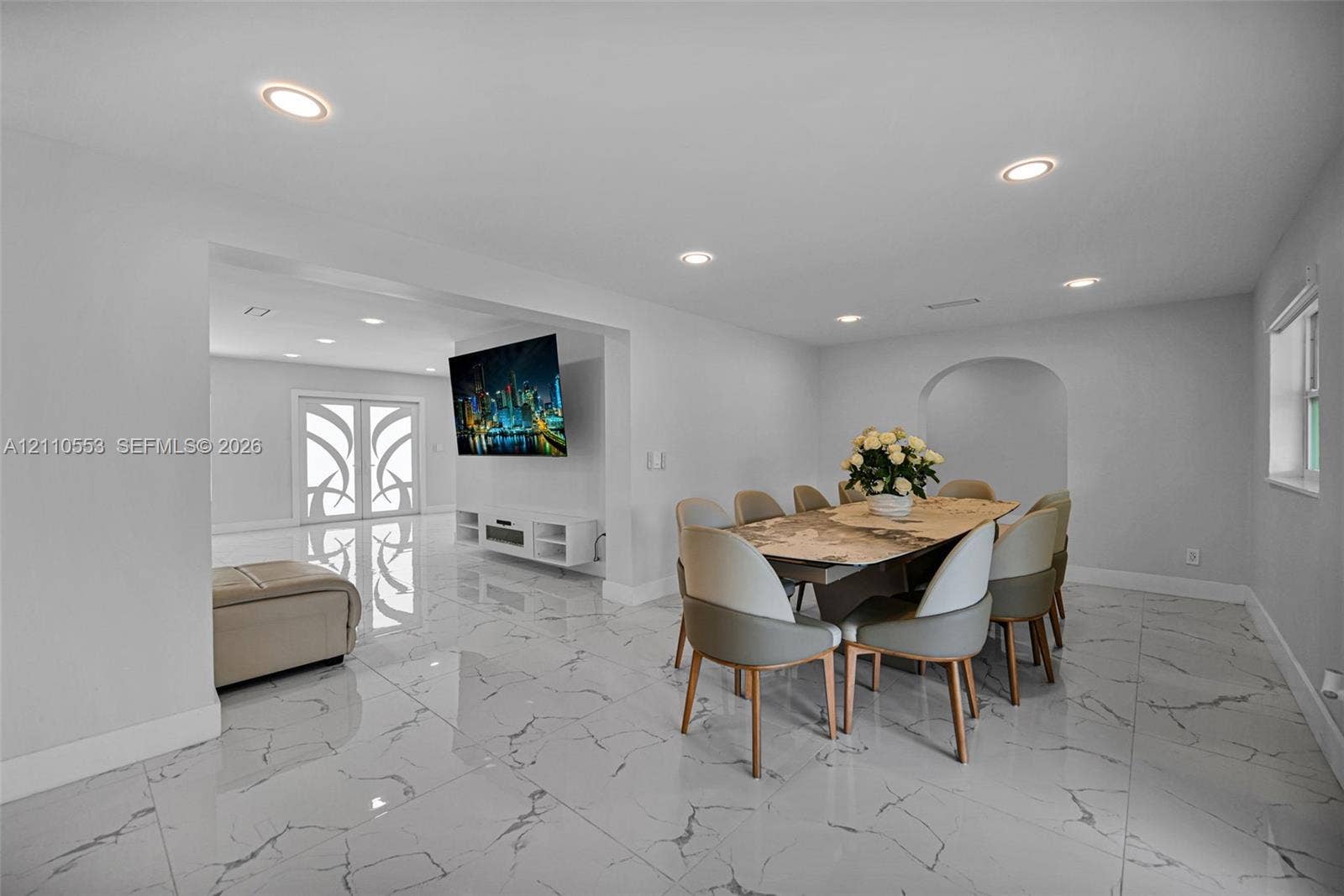 16611 SW 108th Court, Miami, FL 33157 Polished stone-look flooring, recessed lighting, double entry doors with decorative glass inserts, and a distinct arched doorway