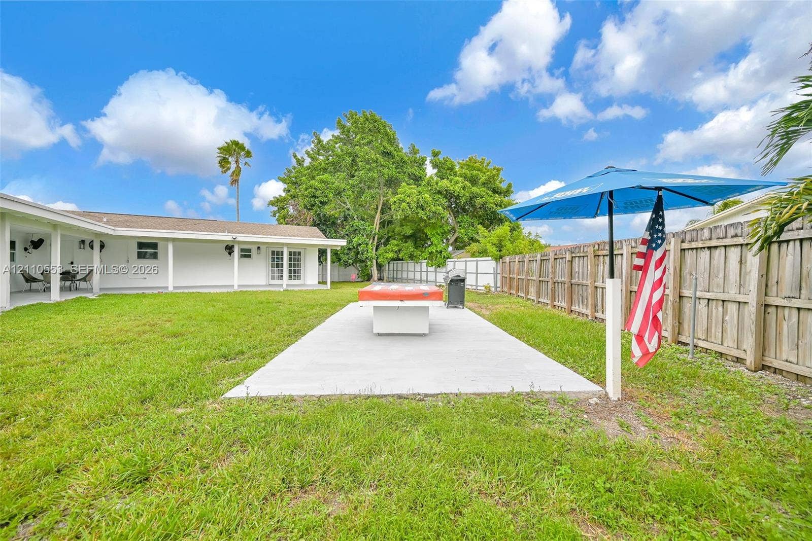 16611 SW 108th Court, Miami, FL 33157 Expansive backyard featuring a concrete patio, a covered porch, and wood-panel fencing