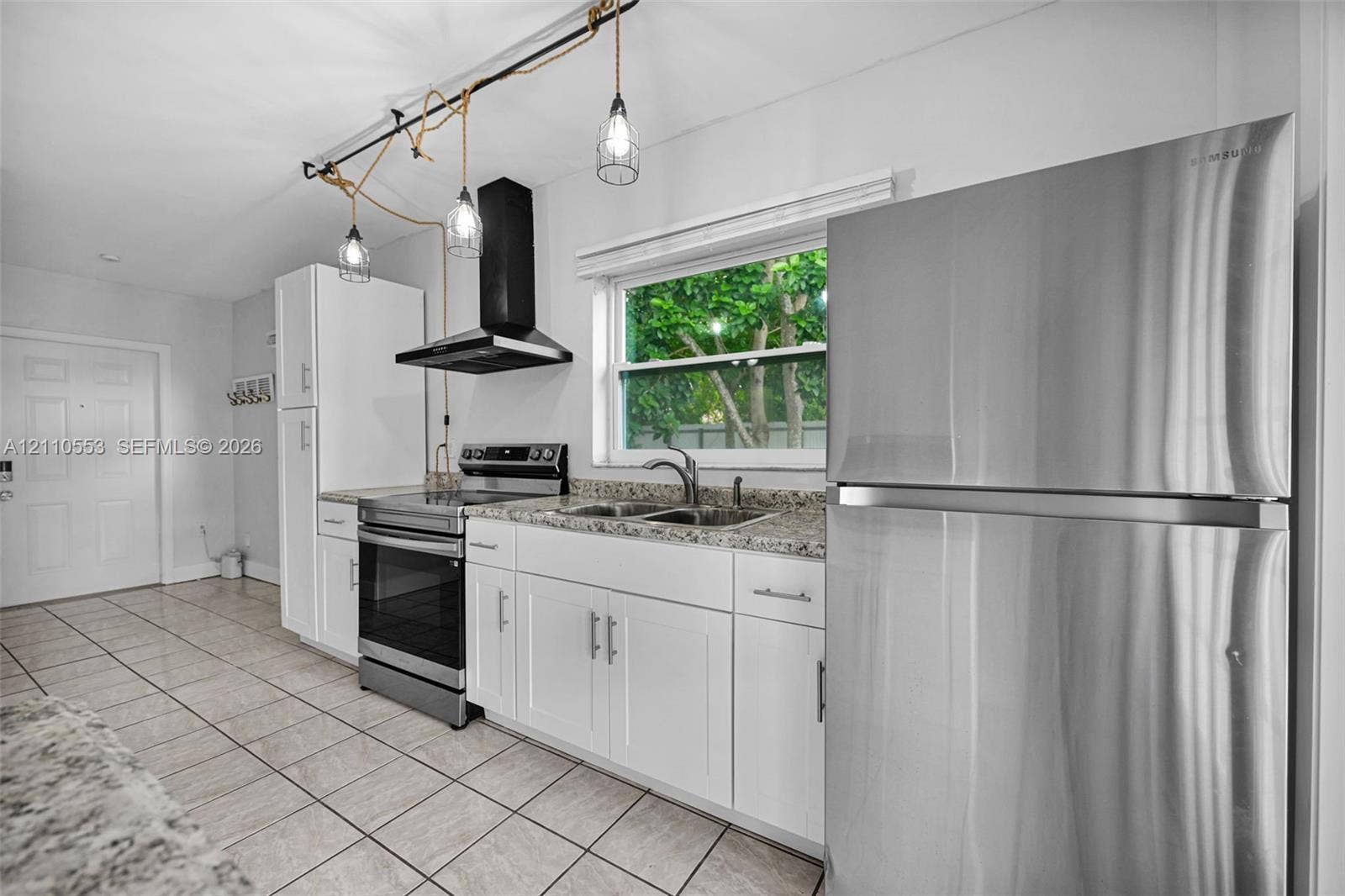 16611 SW 108th Court, Miami, FL 33157 Kitchen featuring white cabinetry, stone-finish countertops, stainless steel appliances, tiled flooring, and industrial-style pendant lighting