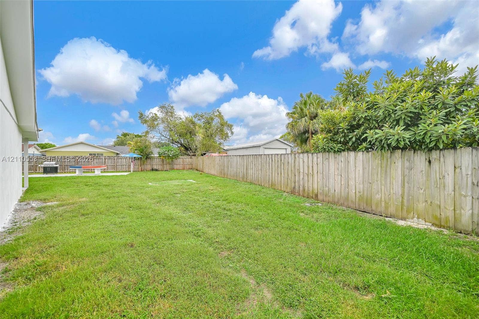 16611 SW 108th Court, Miami, FL 33157 Expansive backyard featuring a level lawn, full-perimeter wood fencing, and mature landscaping