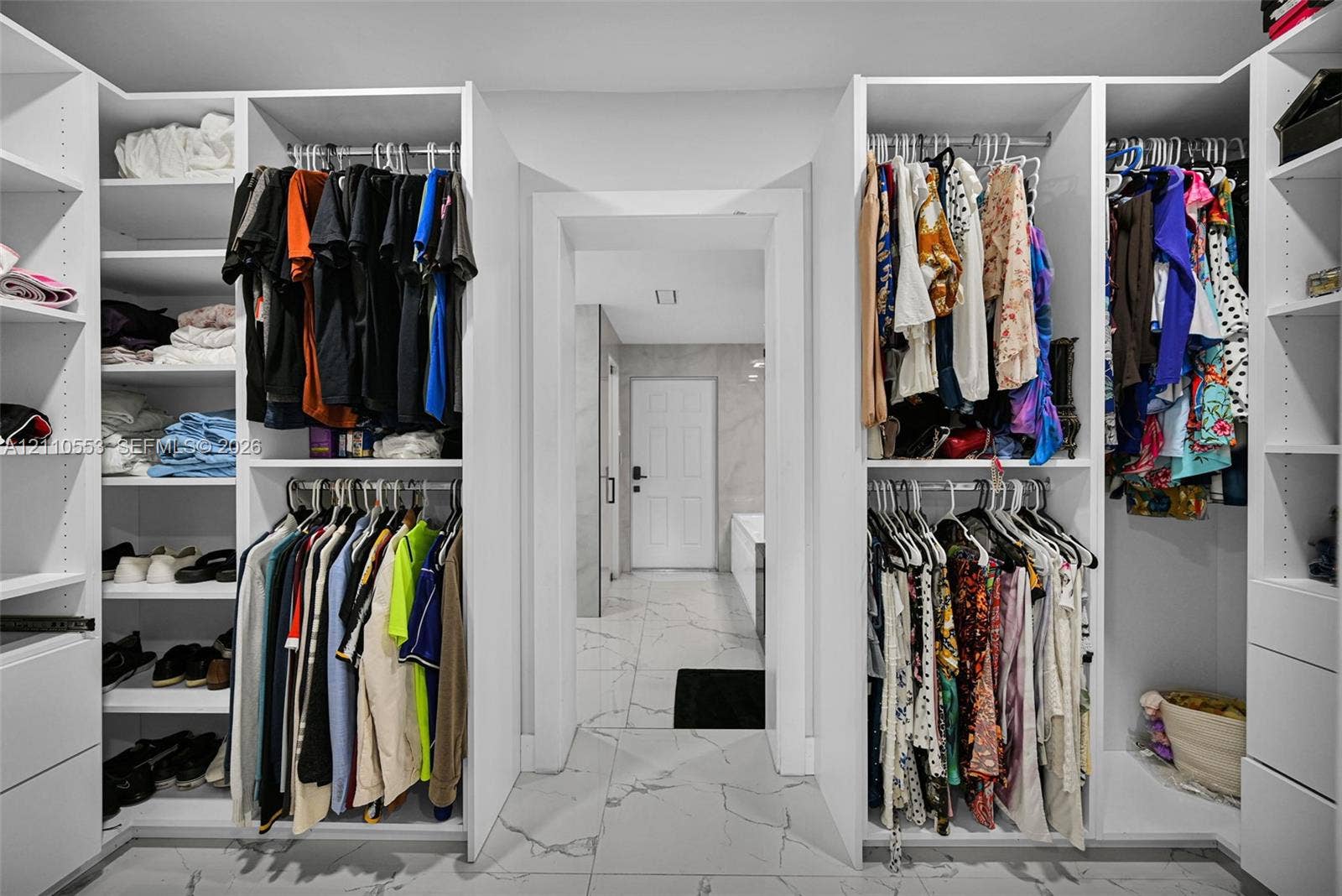 16611 SW 108th Court, Miami, FL 33157 Walk-in dressing area featuring custom white built-in cabinetry, tiered hanging rods, adjustable shelving, and large-format porcelain tile flooring