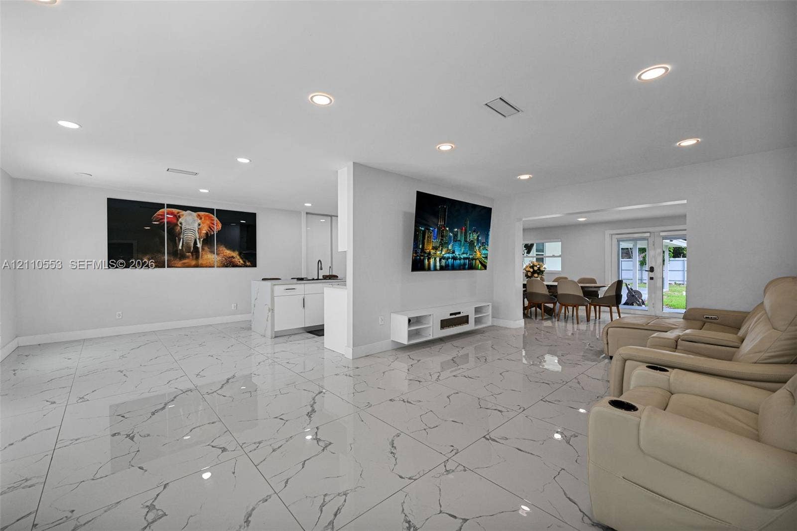 16611 SW 108th Court, Miami, FL 33157 Large-format tile flooring with a neutral-veined pattern, recessed ceiling lighting, kitchen island with cabinetry, and double glass-paneled exterior doors