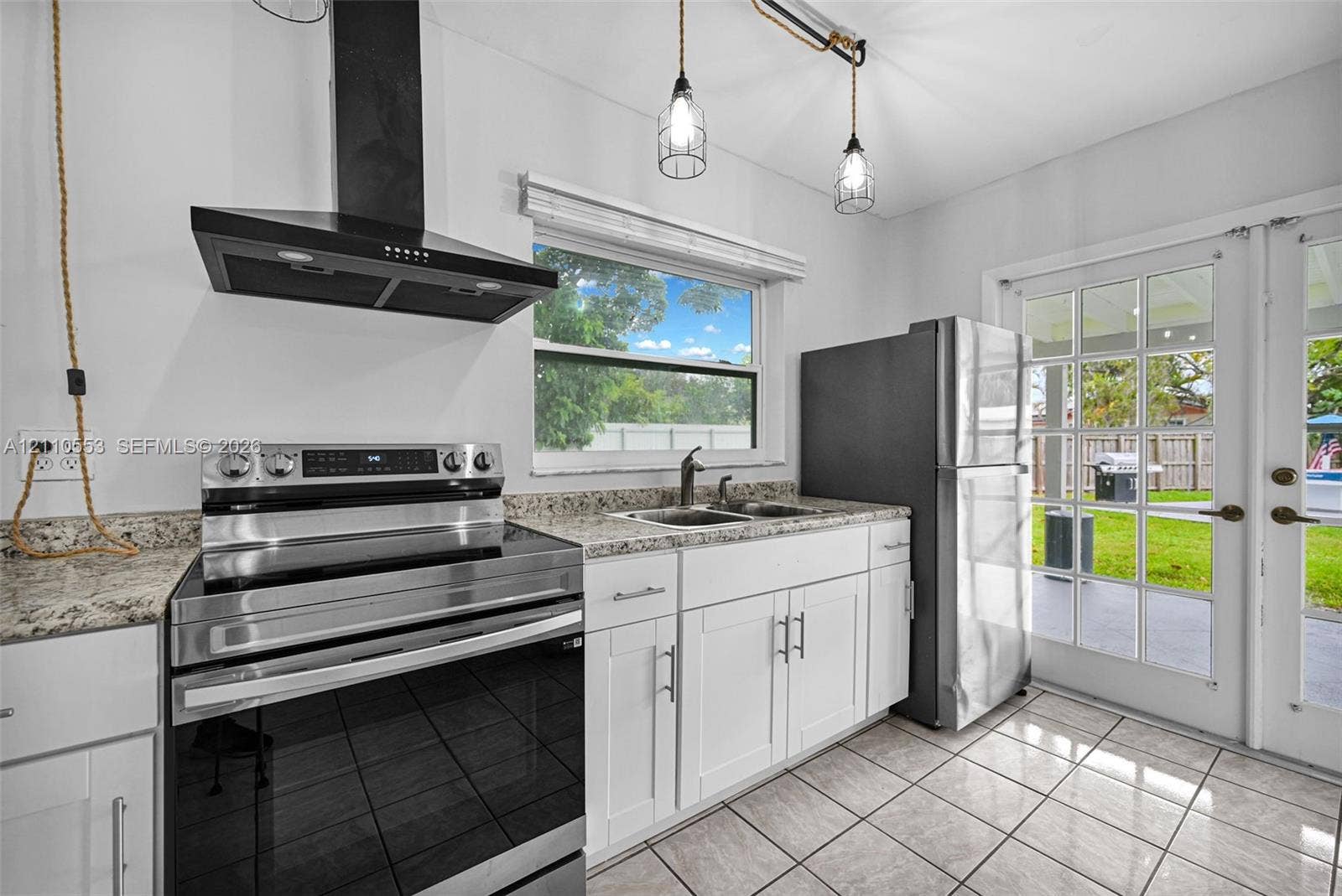 16611 SW 108th Court, Miami, FL 33157 Kitchen featuring white cabinetry, stone-surface countertops, a stainless steel range, a black chimney-style range hood, and tile flooring