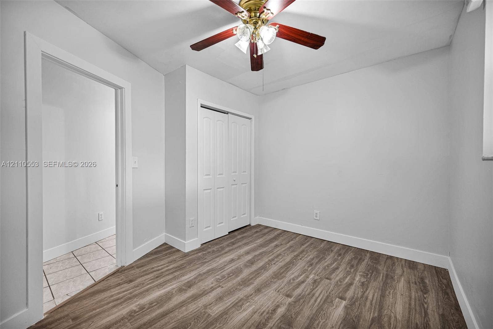 16611 SW 108th Court, Miami, FL 33157 Room featuring wood-finish flooring, a ceiling fan with integrated lighting, and a dual-panel closet door