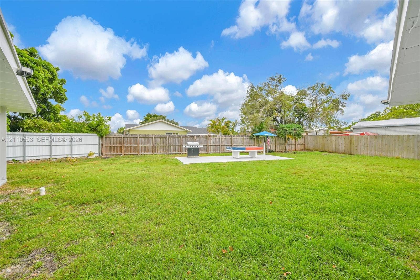 16611 SW 108th Court, Miami, FL 33157 Expansive backyard featuring a level lawn, concrete patio, and wood privacy fencing