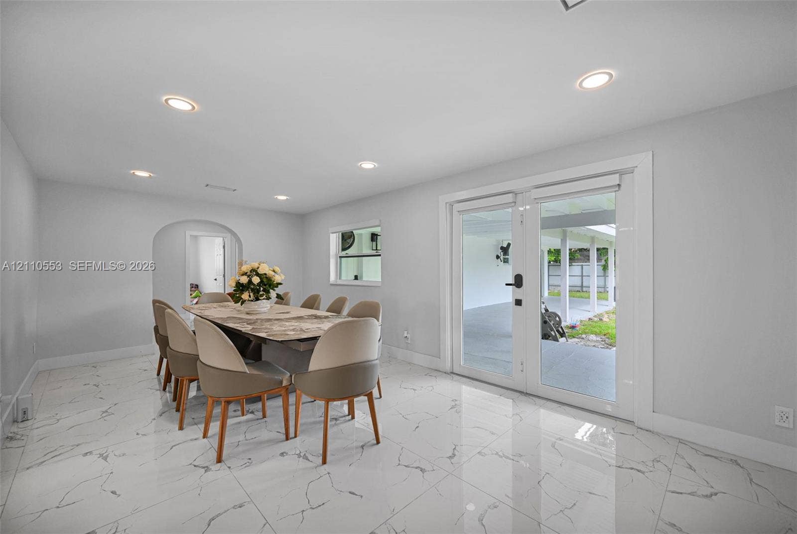 16611 SW 108th Court, Miami, FL 33157 Large-format stone-patterned tile flooring, recessed ceiling lighting, arched entryway, and glass-paneled double doors providing exterior access