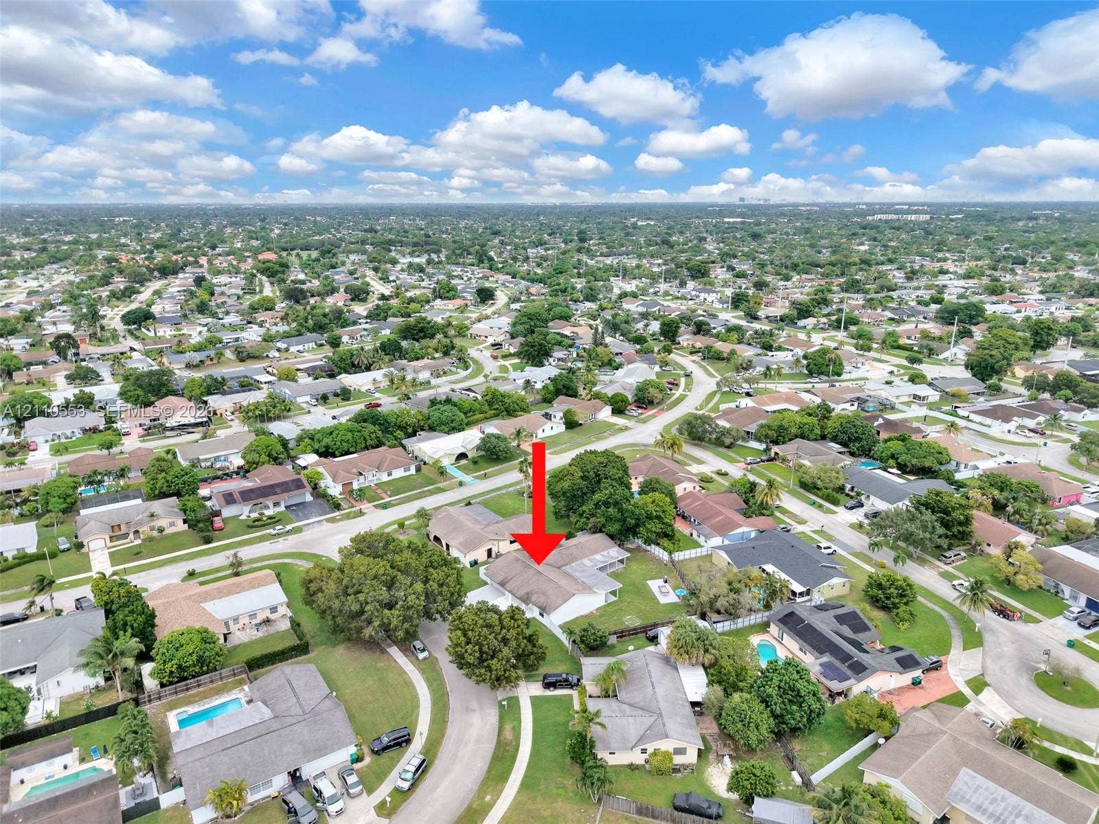 16611 SW 108th Court, Miami, FL 33157 Aerial perspective featuring a single-story residence with a multi-gabled roofline and an attached garage, situated on a corner lot with mature landscaping