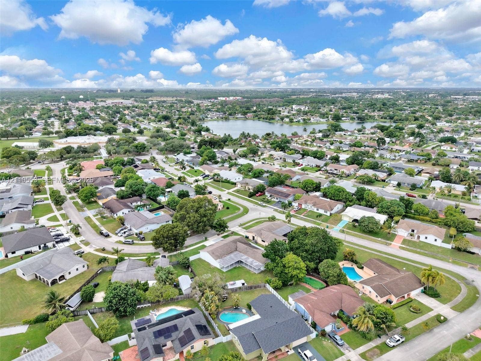 16611 SW 108th Court, Miami, FL 33157 Aerial perspective of a residential neighborhood featuring established tree canopy, diverse housing styles, and a central lake
