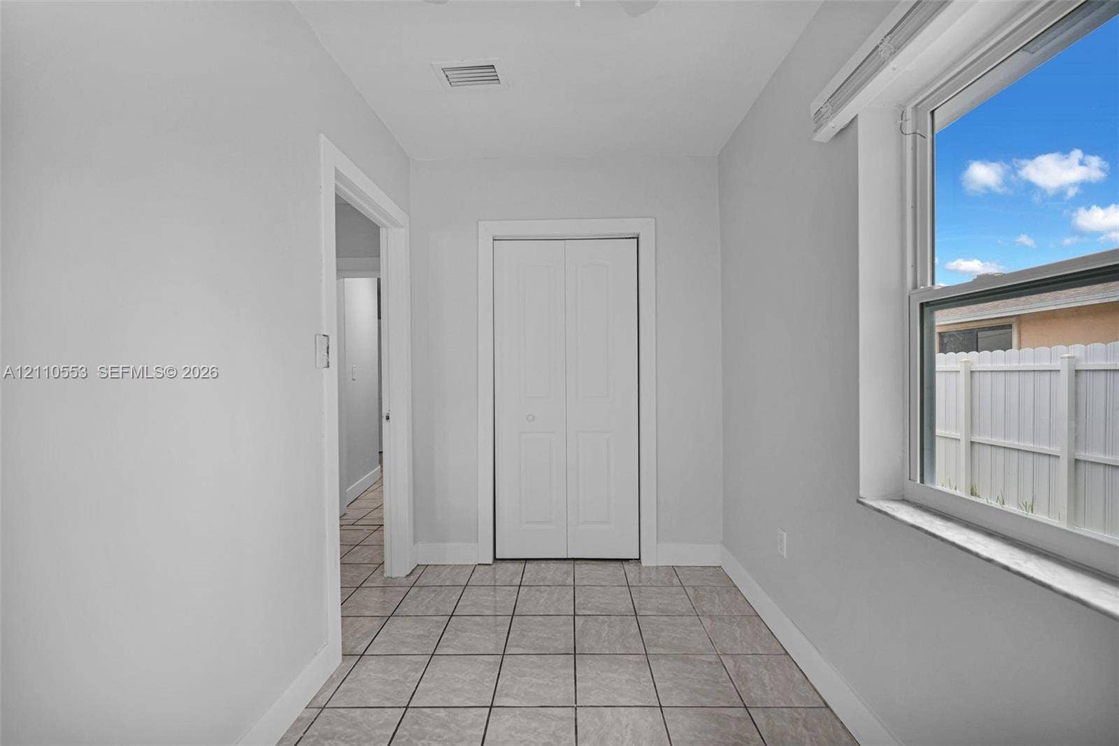 16611 SW 108th Court, Miami, FL 33157 Interior space featuring ceramic tile flooring, a dual-panel closet door, and a single-pane window with a stone-finish sill