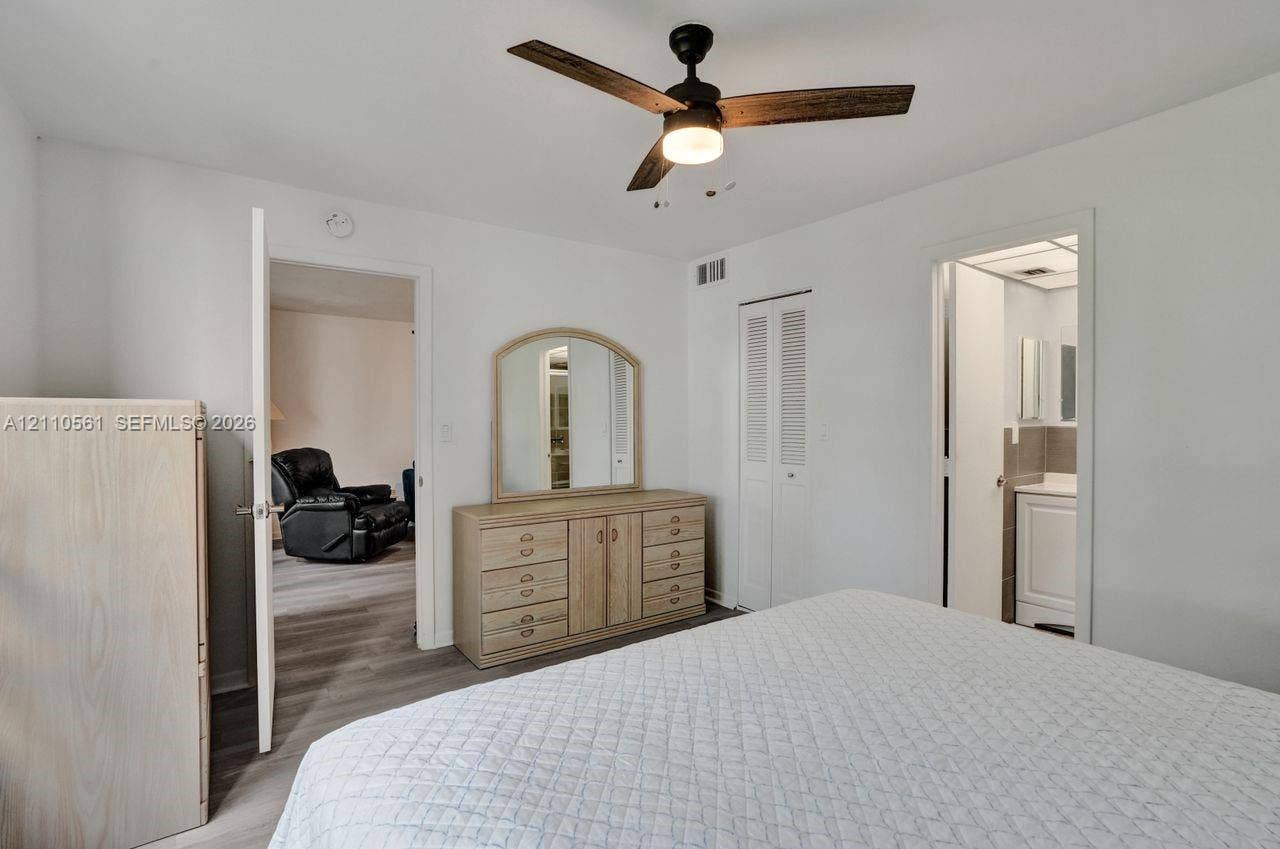 7950 W Mcnab Road, #222, Tamarac, FL 33321 Ceiling fan with integrated lighting, wood-finish flooring, and white louvered-panel closet doors