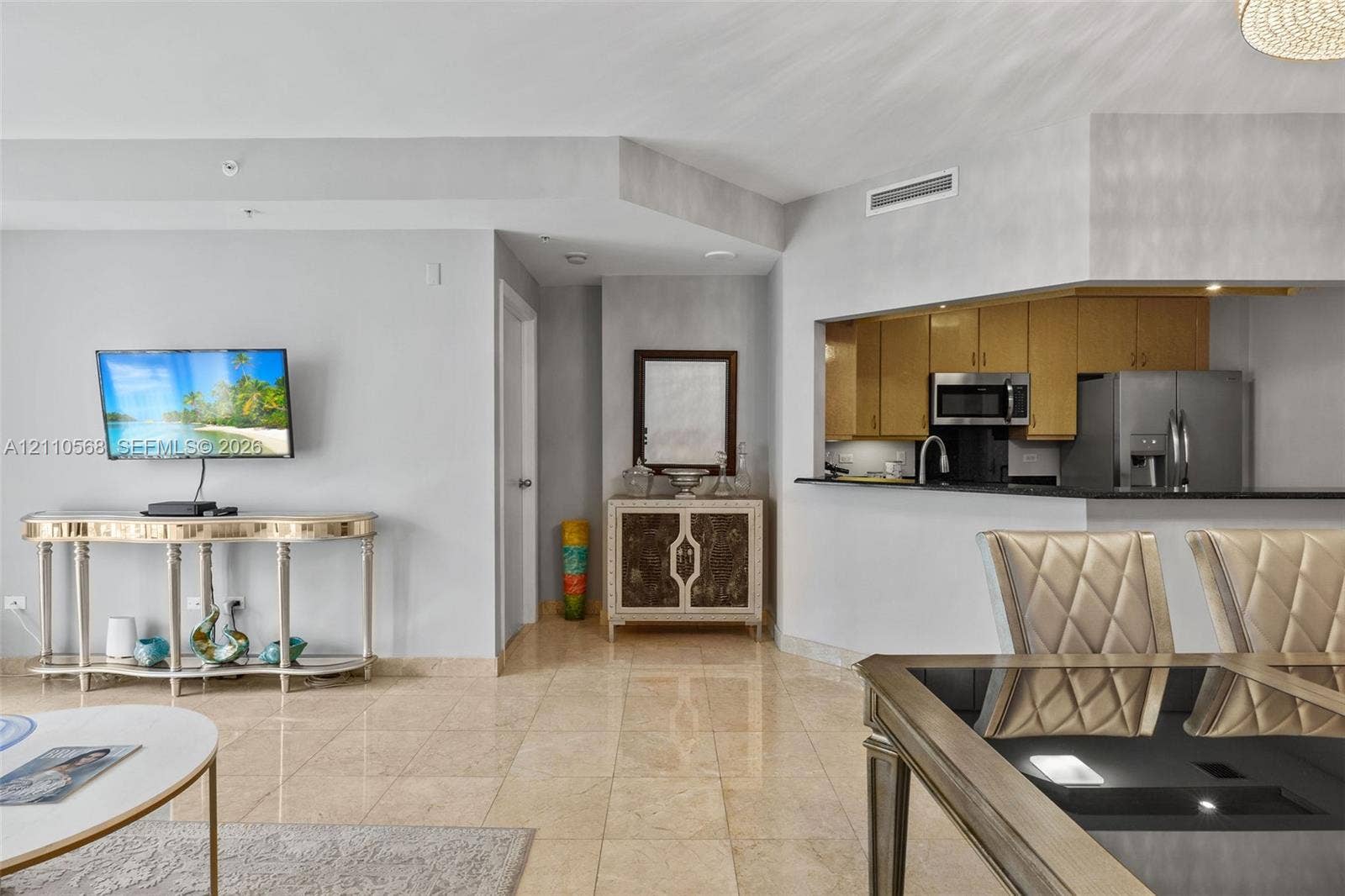 801 Brickell Key Boulevard, #2006, Miami, FL 33131 Polished stone flooring, pass-through window to kitchen, neutral wall tones, and built-in stainless steel appliances