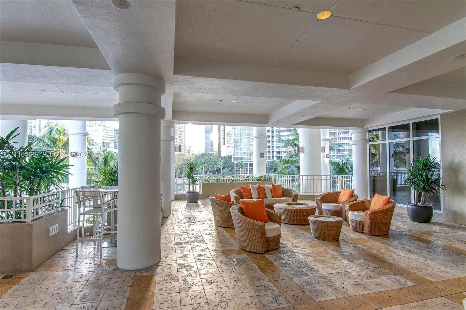 801 Brickell Key Boulevard, #2006, Miami, FL 33131 Covered outdoor terrace featuring stone tile flooring, prominent architectural columns, recessed ceiling lighting, and metal perimeter railing