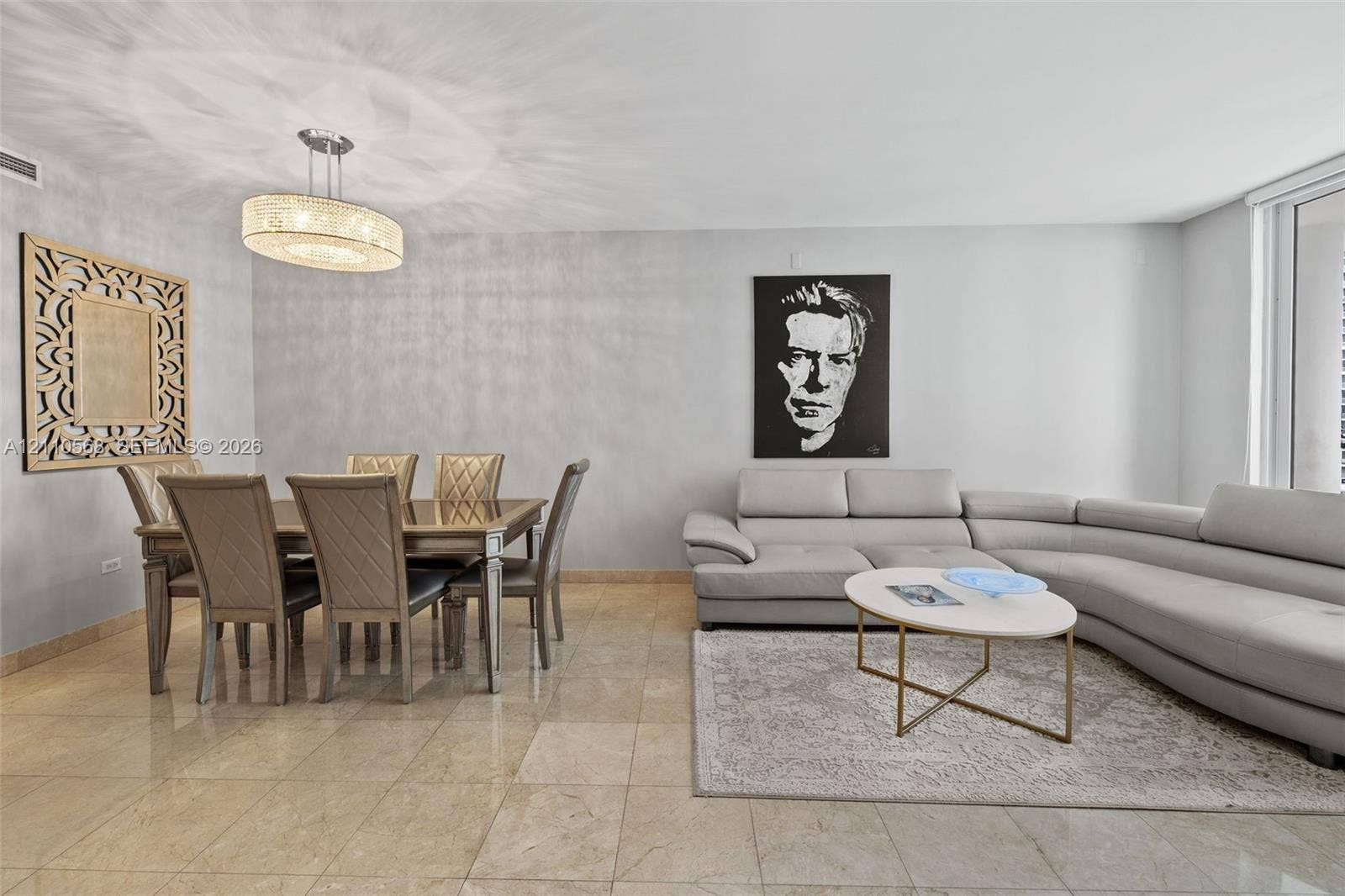 801 Brickell Key Boulevard, #2006, Miami, FL 33131 Open-concept living space featuring large-format tile flooring, textured wall finishes, and a contemporary drum-style chandelier with a crystalline fringe