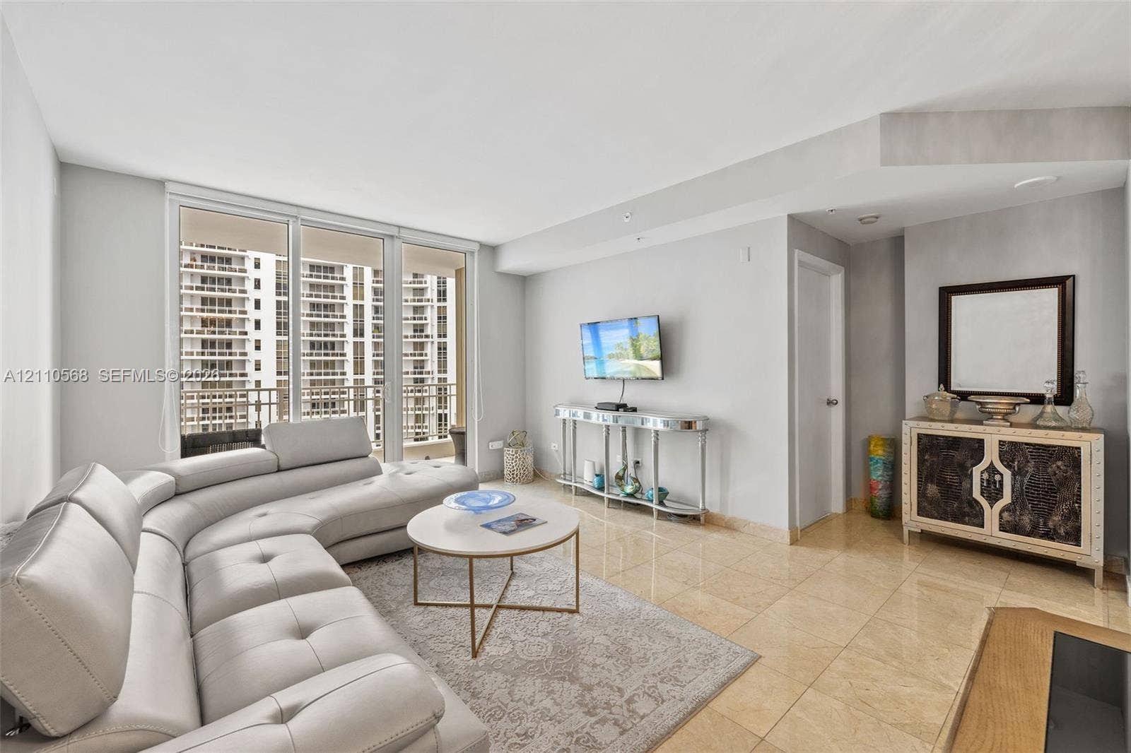 801 Brickell Key Boulevard, #2006, Miami, FL 33131 Living area featuring floor-to-ceiling glass sliding doors, stone tile flooring, and neutral wall tones