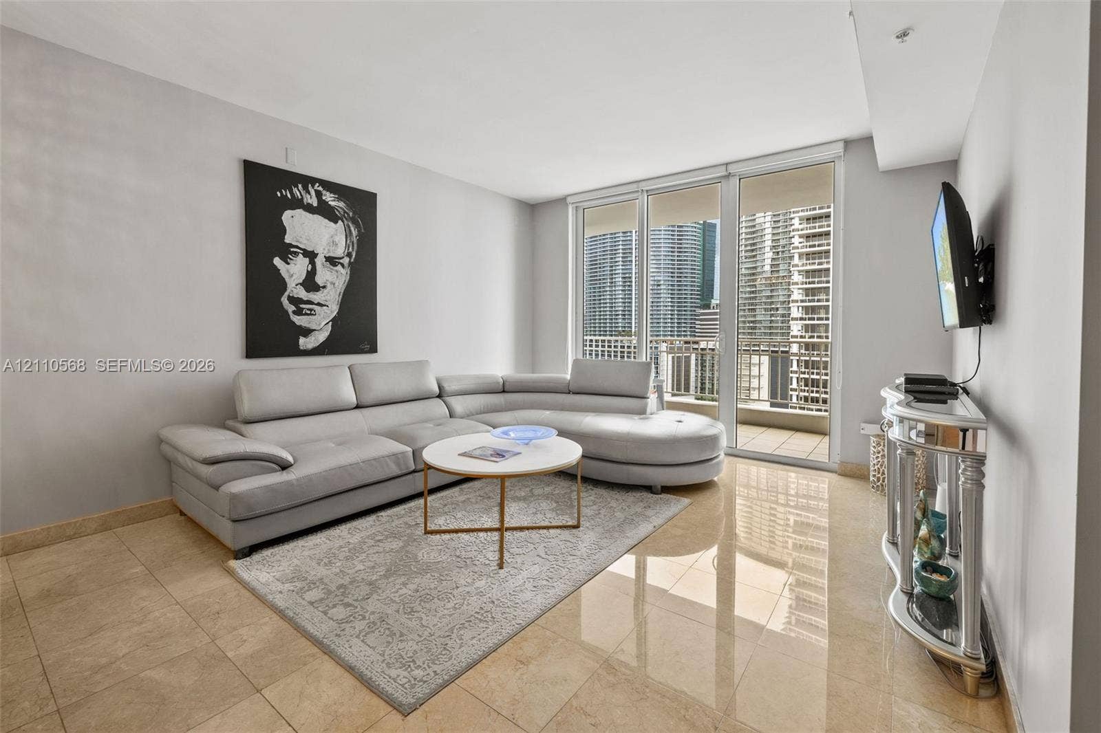 801 Brickell Key Boulevard, #2006, Miami, FL 33131 Living area featuring neutral-toned tile flooring, floor-to-ceiling glass panel doors, and an attached balcony