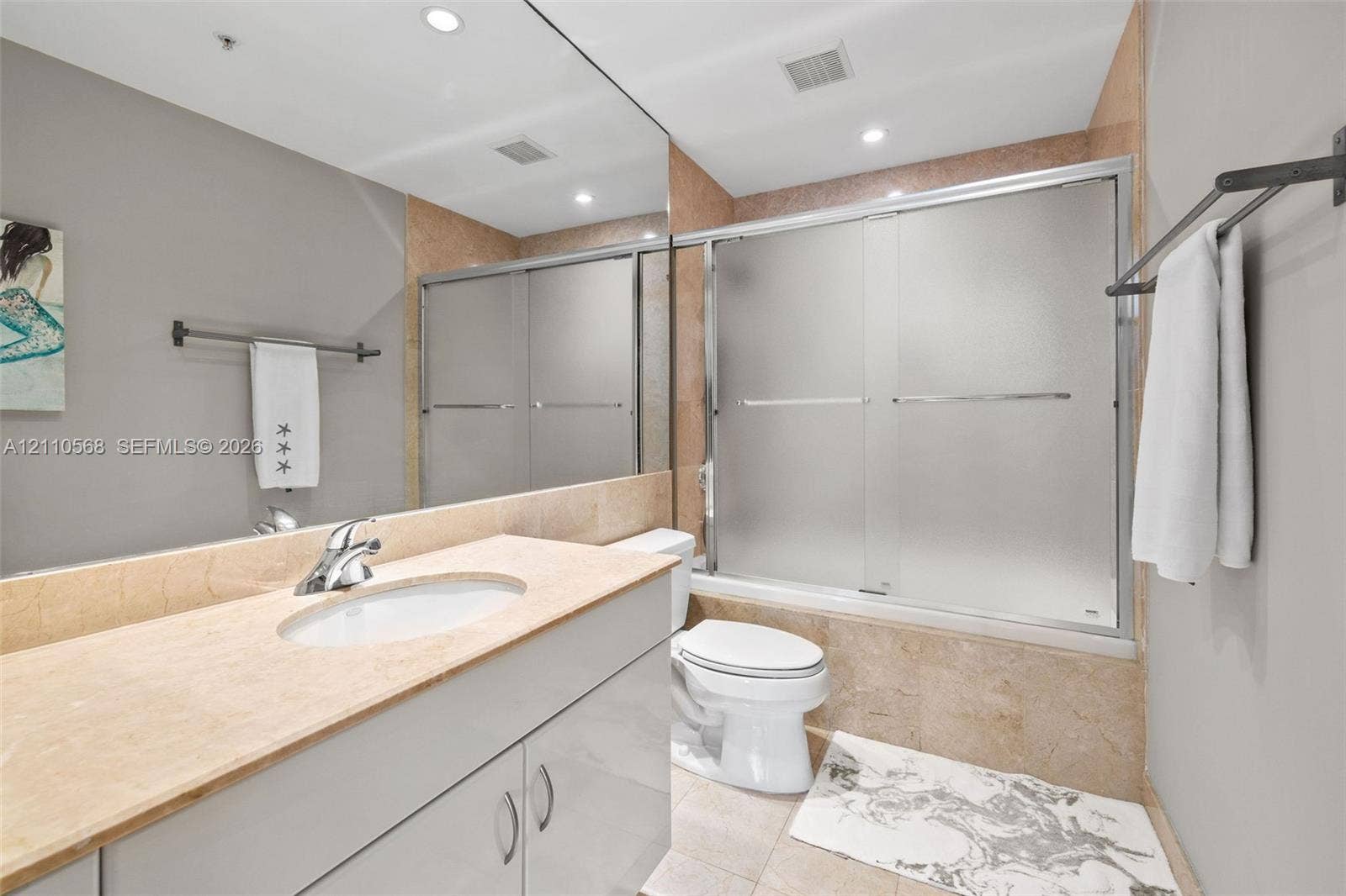 801 Brickell Key Boulevard, #2006, Miami, FL 33131 Bathroom featuring a vanity with a stone countertop, an integrated sink, full-width wall mirror, and a tub-shower combination with sliding frosted-glass doors