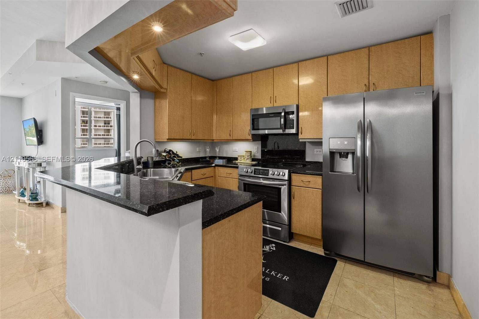 801 Brickell Key Boulevard, #2006, Miami, FL 33131 Kitchen featuring light-finish cabinetry, dark solid-surface countertops, stainless steel appliances, and tiled flooring