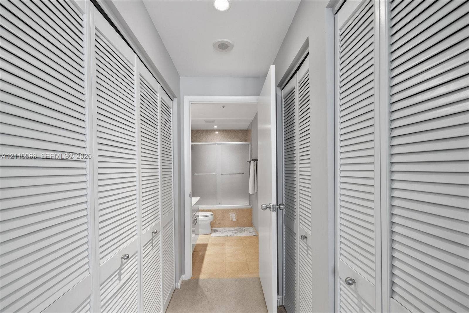 801 Brickell Key Boulevard, #2006, Miami, FL 33131 Hallway featuring white louvered-style closet doors, recessed ceiling lighting, and tile flooring