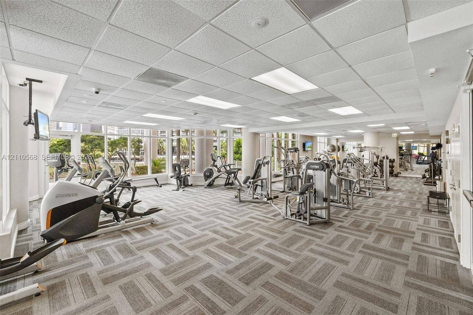 801 Brickell Key Boulevard, #2006, Miami, FL 33131 Fitness facility featuring a drop ceiling with recessed lighting, wall-to-wall carpeted flooring, and floor-to-ceiling windows
