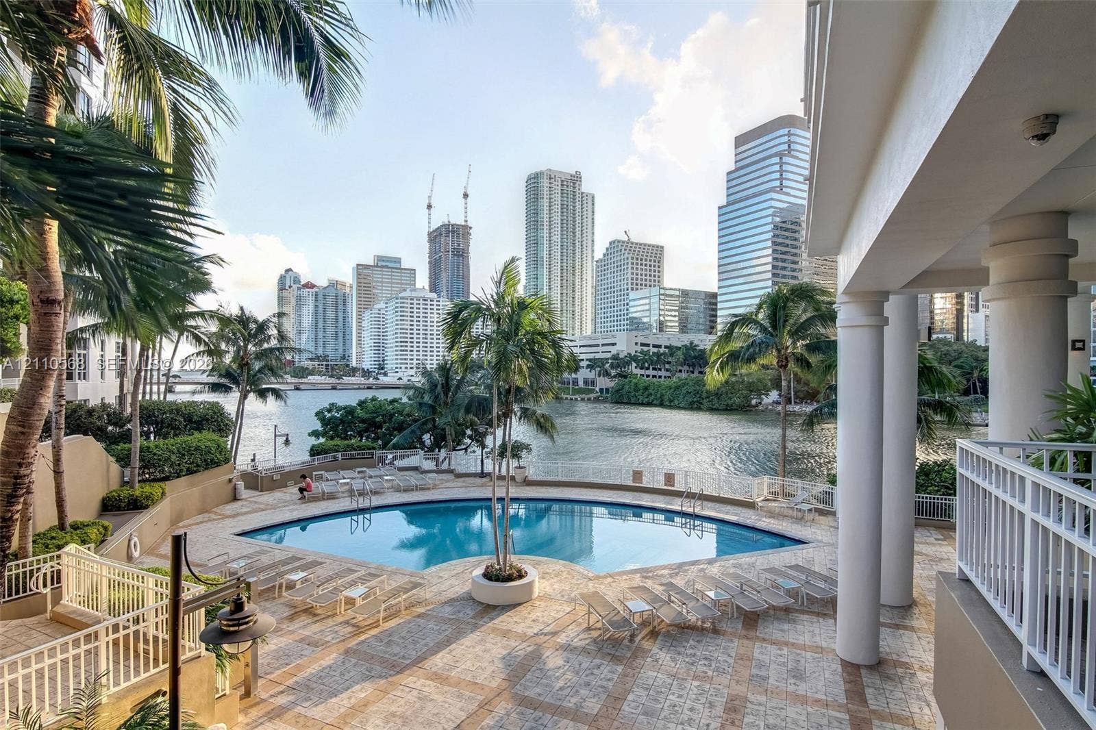 801 Brickell Key Boulevard, #2006, Miami, FL 33131 Covered terrace with structural columns, stone-paved pool deck, swimming pool, and water frontage