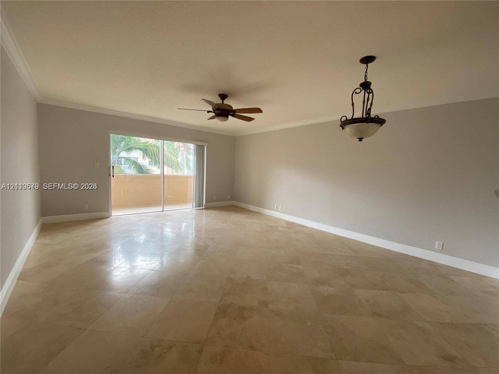 232 NE 12th Avenue, #301, Hallandale Beach, FL 33009 Large room featuring neutral-toned stone-finish flooring, crown molding, a ceiling fan, and a decorative pendant light fixture with sliding glass doors opening to an exterior balcony