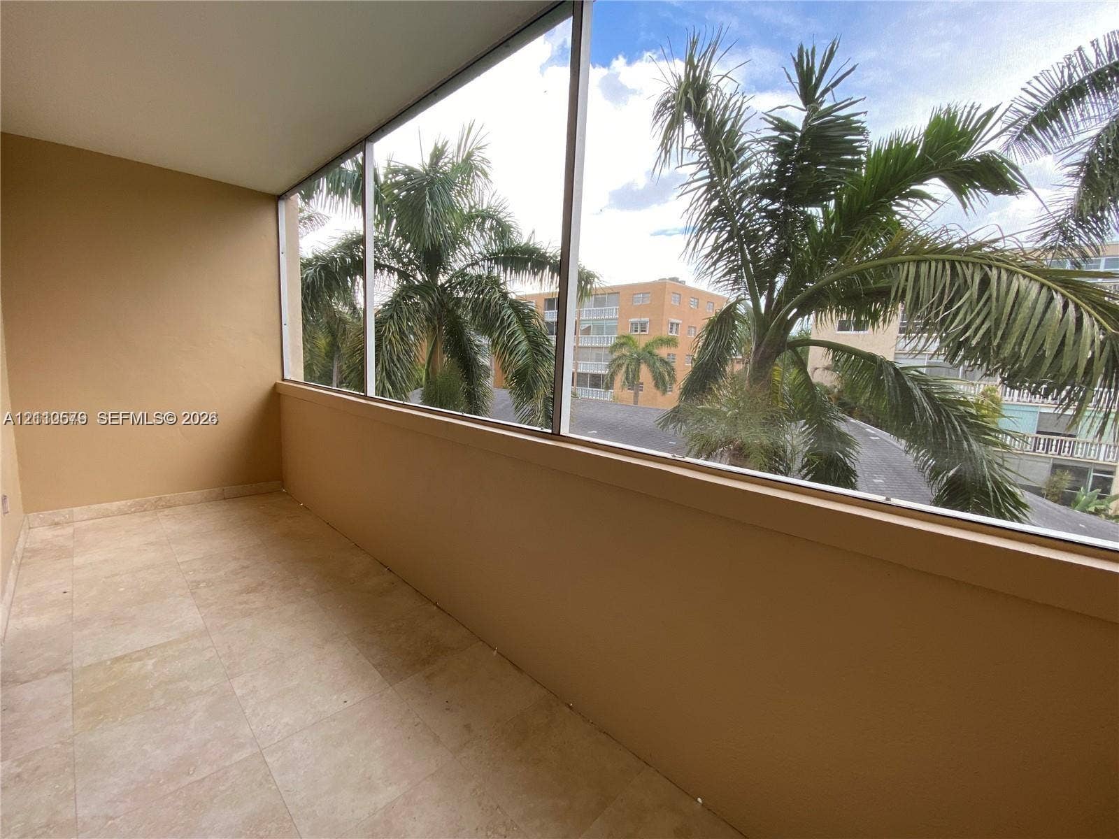 232 NE 12th Avenue, #301, Hallandale Beach, FL 33009 Enclosed balcony featuring light-toned tile flooring, solid wall construction, and expansive screened window panels