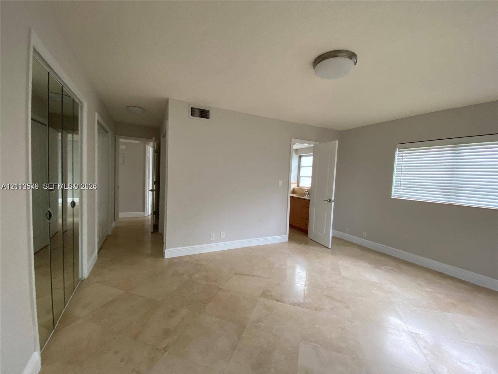 232 NE 12th Avenue, #301, Hallandale Beach, FL 33009 Interior space featuring light-toned stone-finish flooring, floor-to-ceiling mirrored closet doors, and recessed ceiling lighting