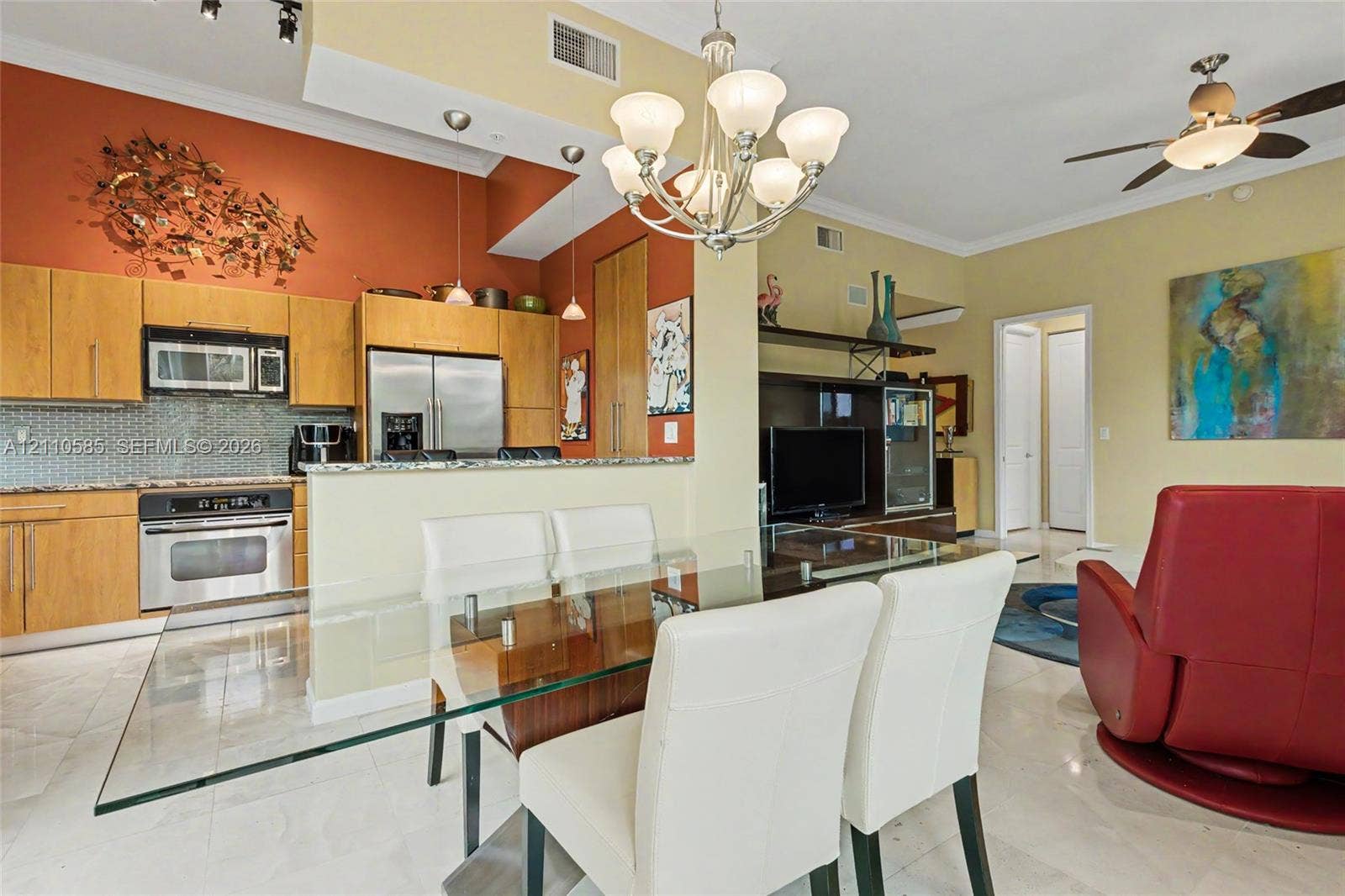 600 W Las Olas Boulevard, #202S, Fort Lauderdale, FL 33312 Kitchen featuring wood cabinetry, stone countertops, glass tile backsplash, stainless steel appliances, and pantry.