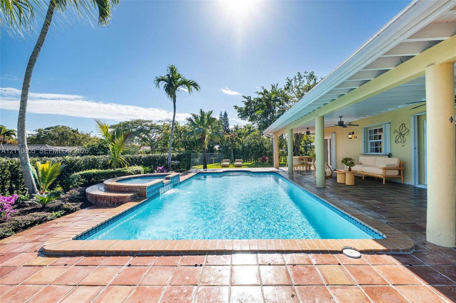 Screened-in patio with tile flooring and a covered exterior area featuring a built-in swimming pool and raised spa