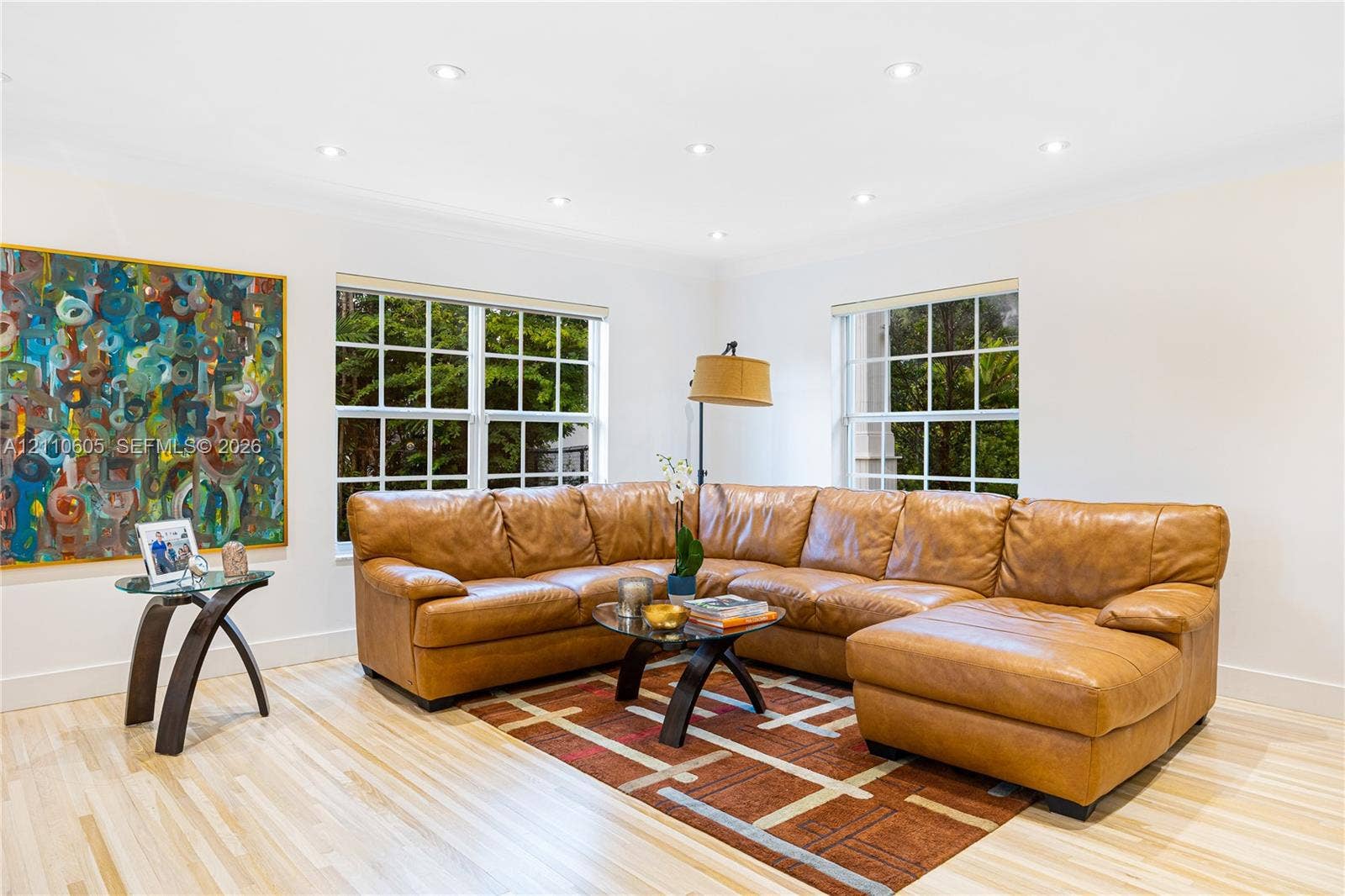 Living area featuring light-toned wood-finish flooring, recessed ceiling lighting, and multi-pane windows