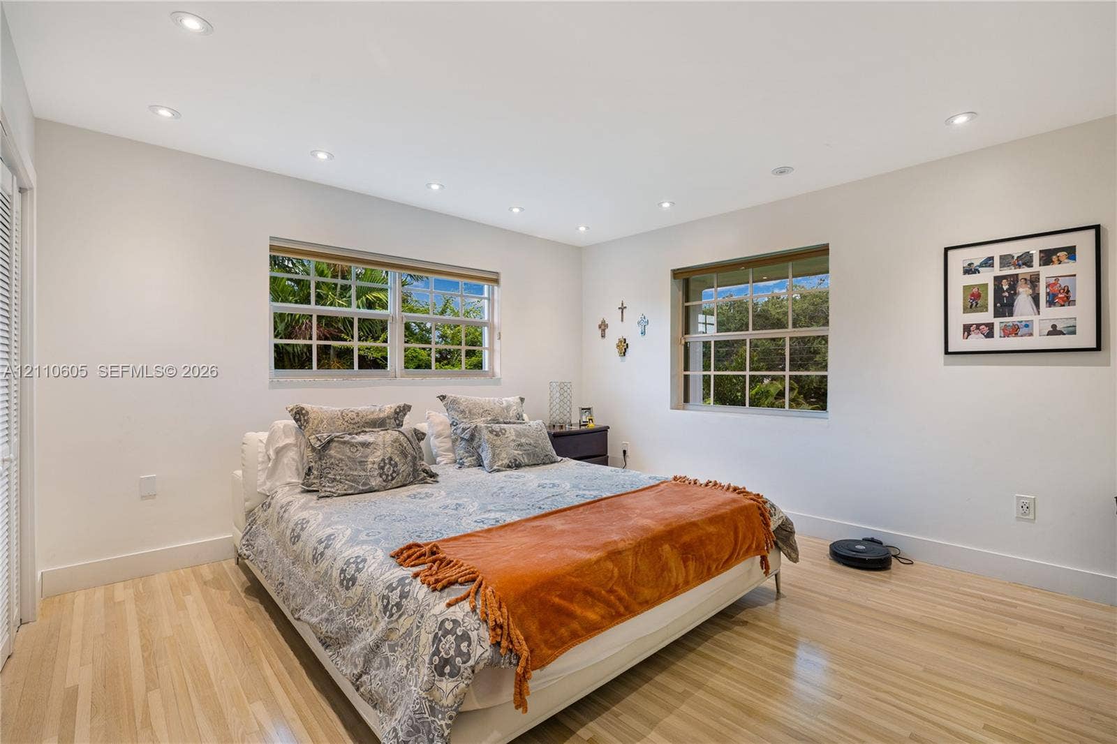 Neutral-toned room featuring light wood-finish flooring, recessed lighting, and dual grid-pattern windows