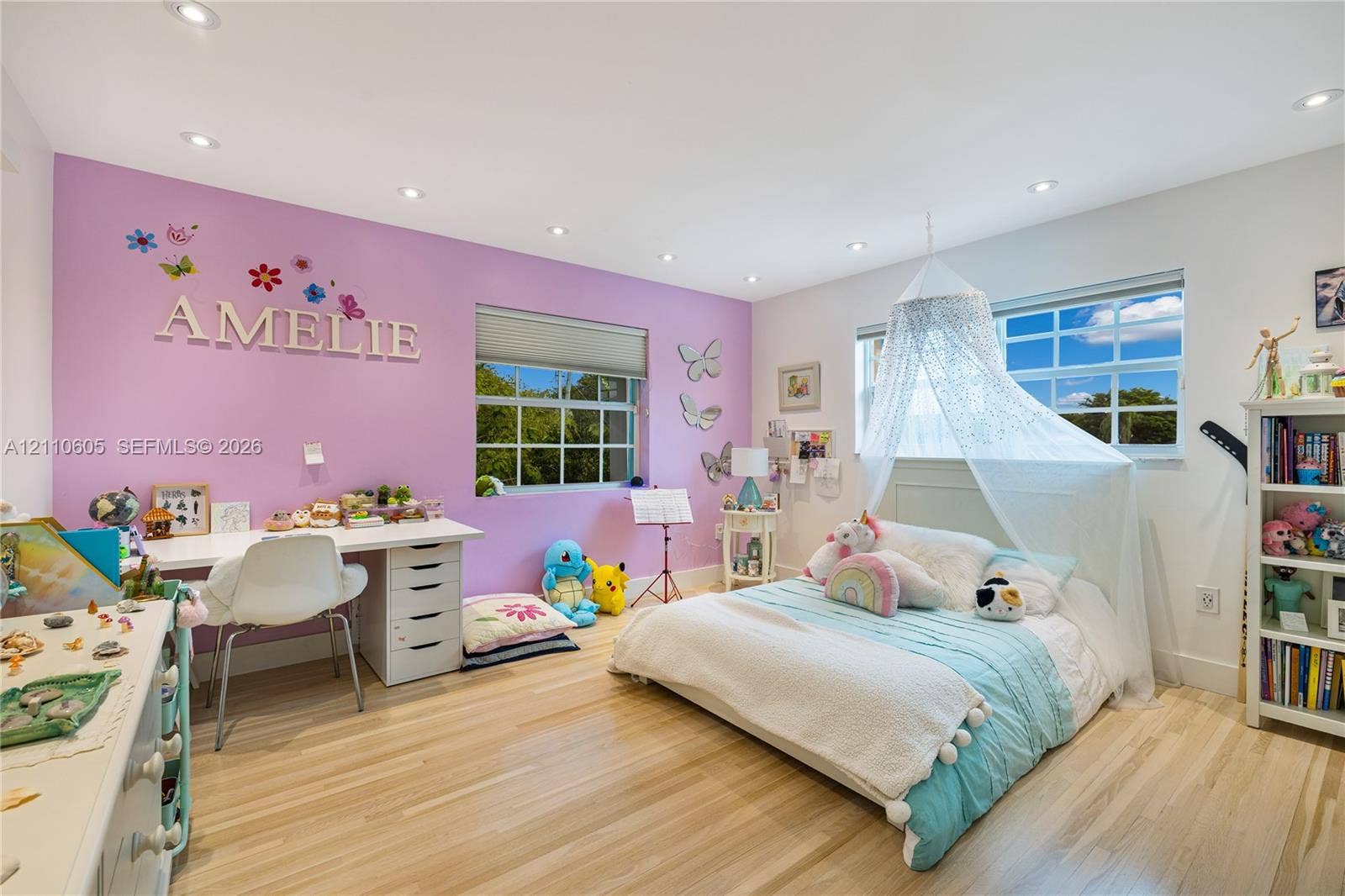 Spacious room featuring light-toned wood-finish flooring, recessed lighting, and multi-pane windows