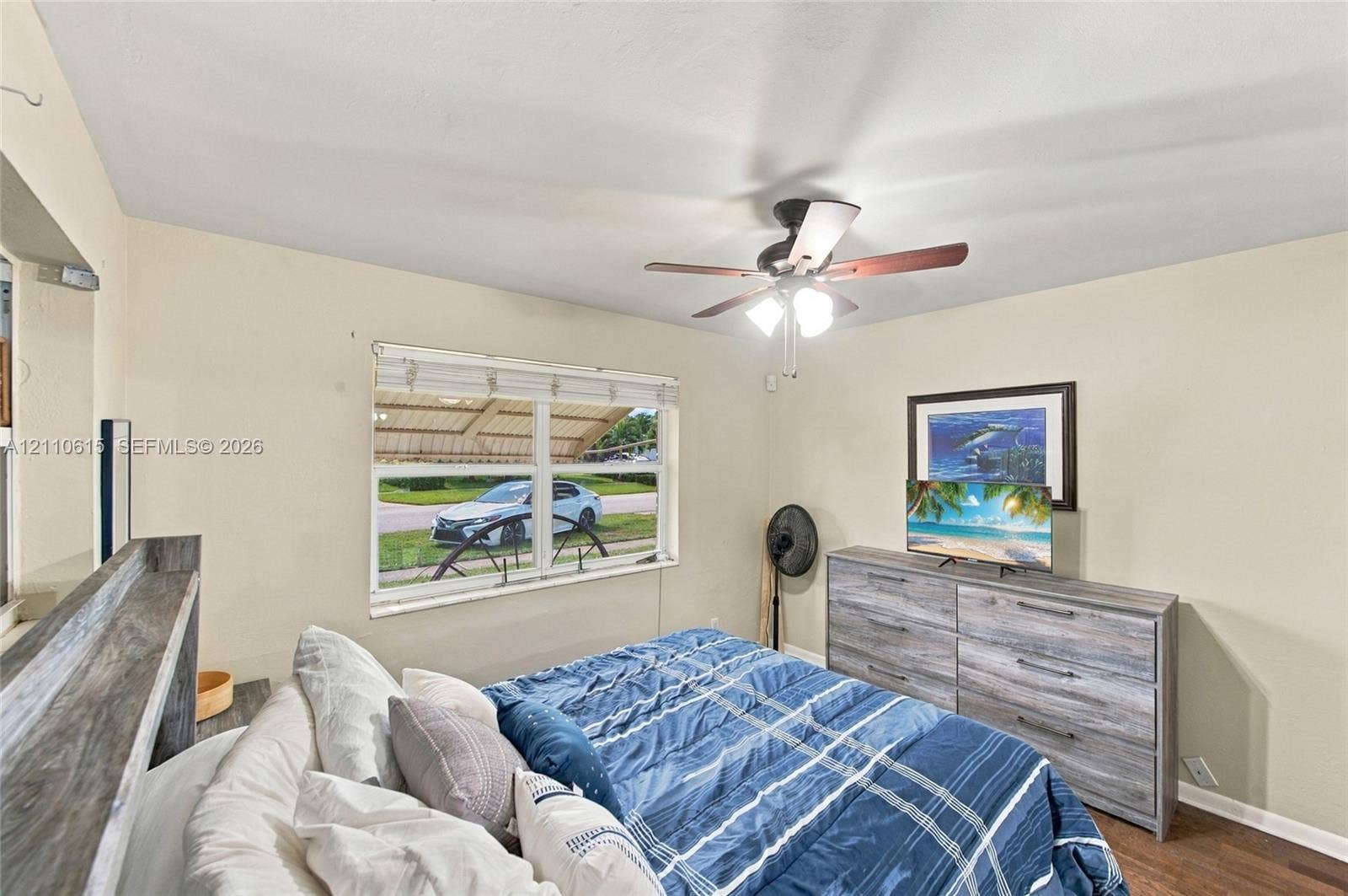 Neutral wall tones, dual-pane window, and a multi-blade ceiling fan with integrated lighting