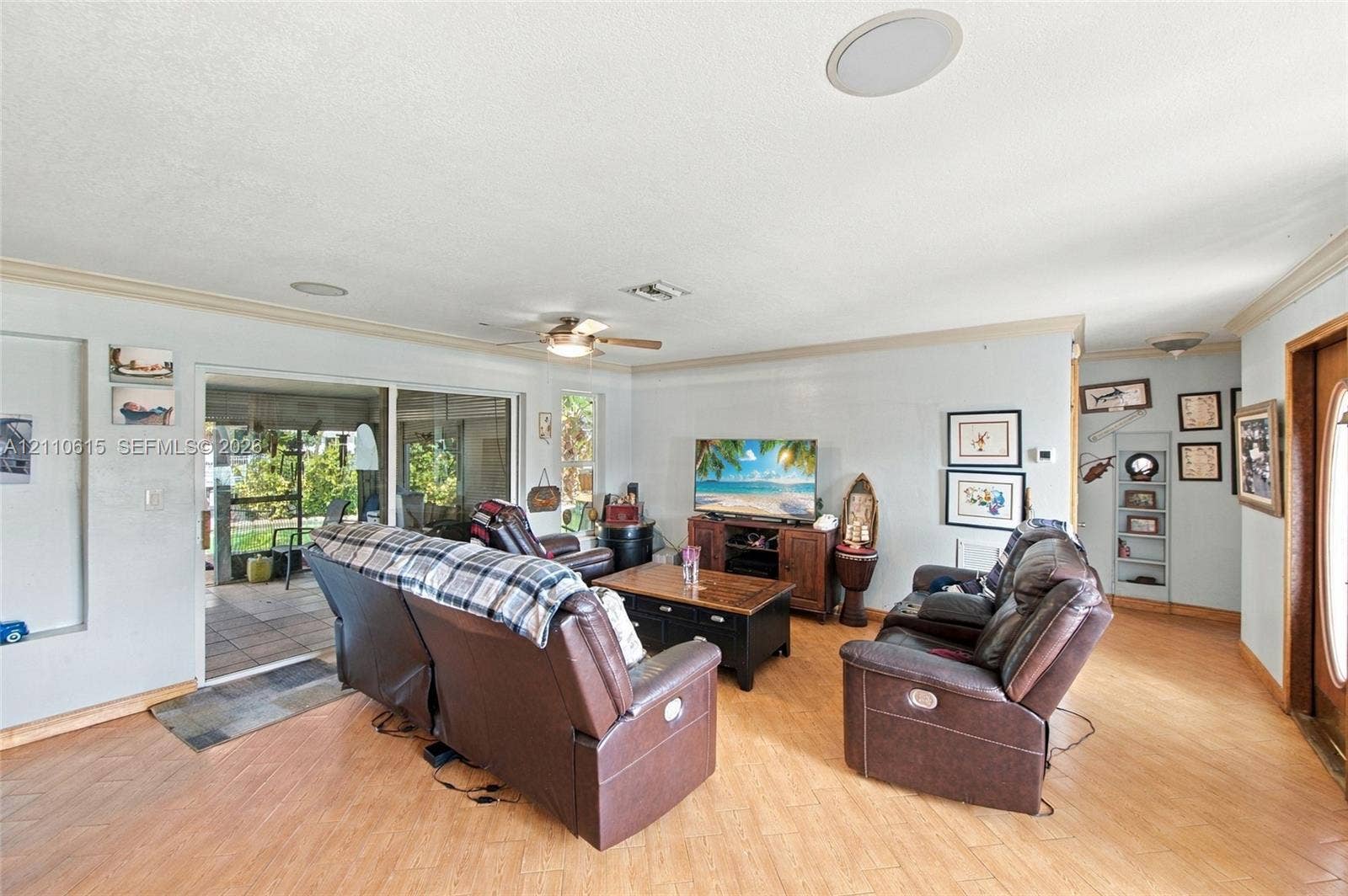 Living area featuring wood-finish flooring, recessed lighting, ceiling fan, and sliding glass doors