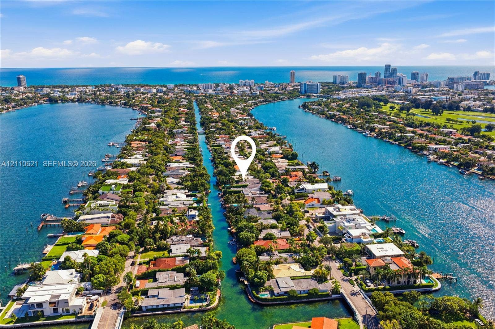 Aerial perspective of a waterfront property situated on a canal with direct access to the ocean and proximity to the city skyline