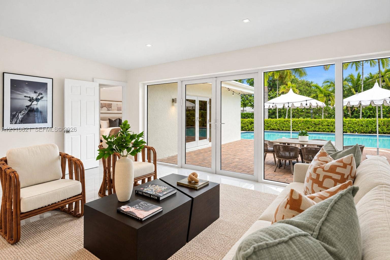 Interior featuring tile flooring, recessed lighting, and expansive glass doors opening to a brick-paved patio with an in-ground swimming pool