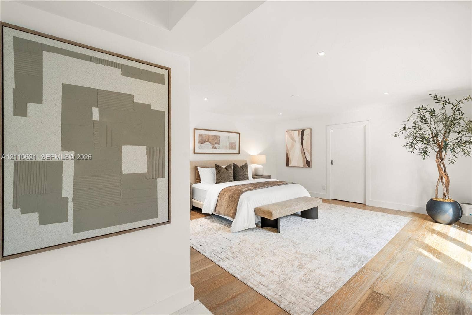 Spacious room featuring wood-finish flooring, recessed lighting, and crisp white walls