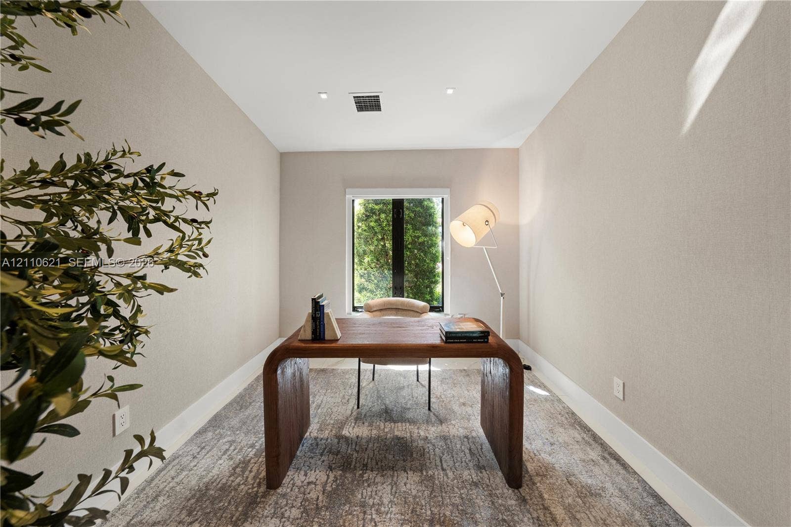 Neutral-toned wall finishes, recessed ceiling lighting, and a single-pane window with a black frame