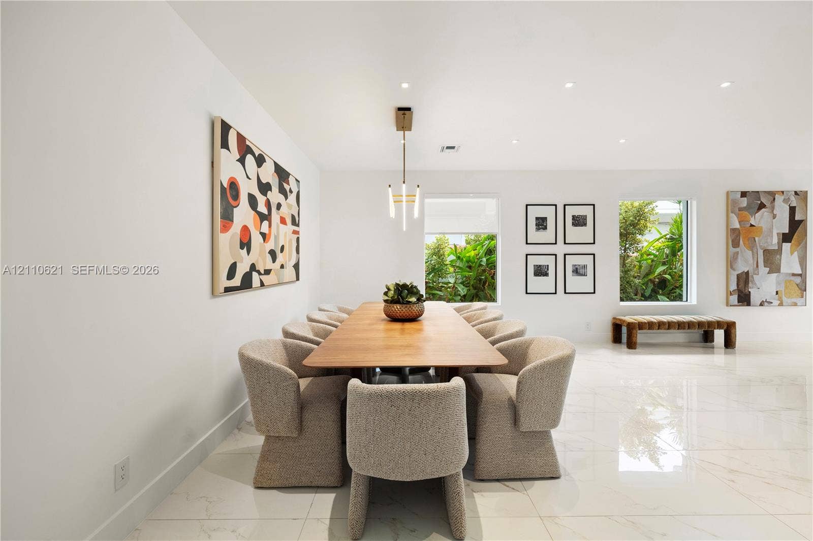 Large-format polished tile flooring, recessed ceiling lighting, and a modern tiered chandelier