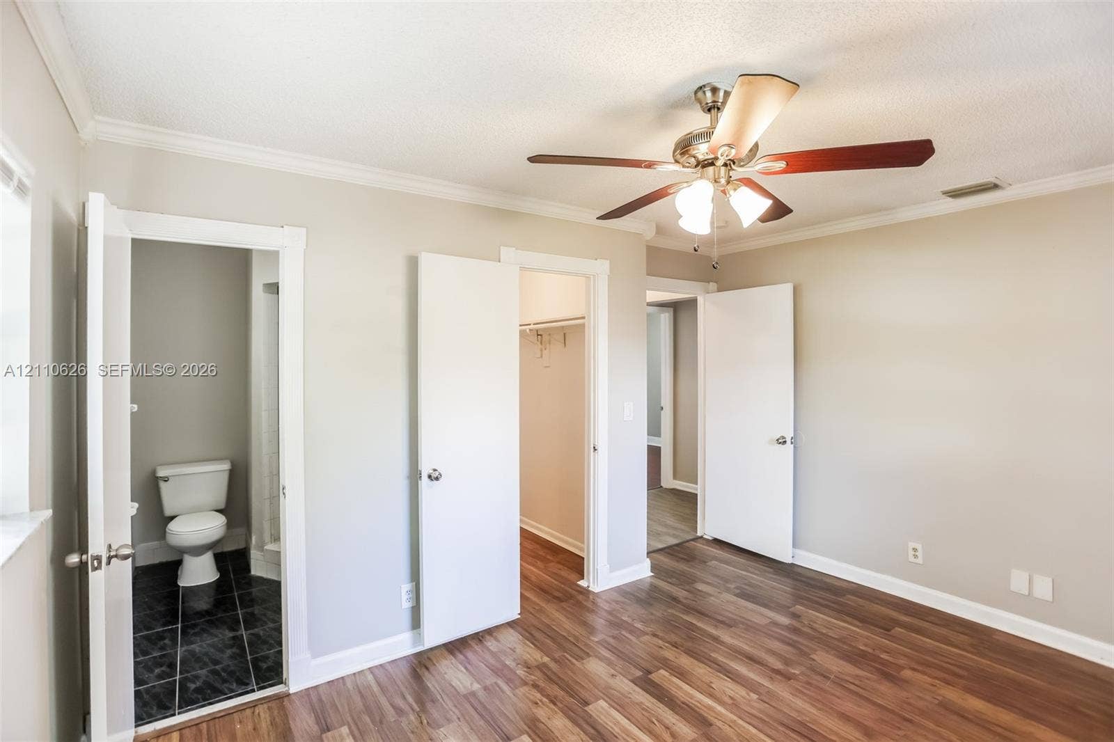 1301 NW 2nd Street, Dania, Dania Beach, FL 33004 Wood-finish flooring, ceiling fan with integrated light fixture, crown molding, and two interior doorways with built-in storage