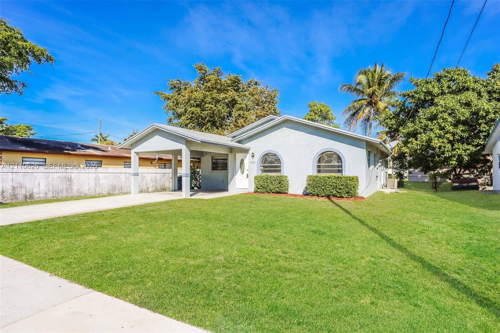1301 NW 2nd Street, Dania, Dania Beach, FL 33004 Single-story residence featuring a light-toned stucco exterior, arched front windows, a covered entryway, and a concrete driveway