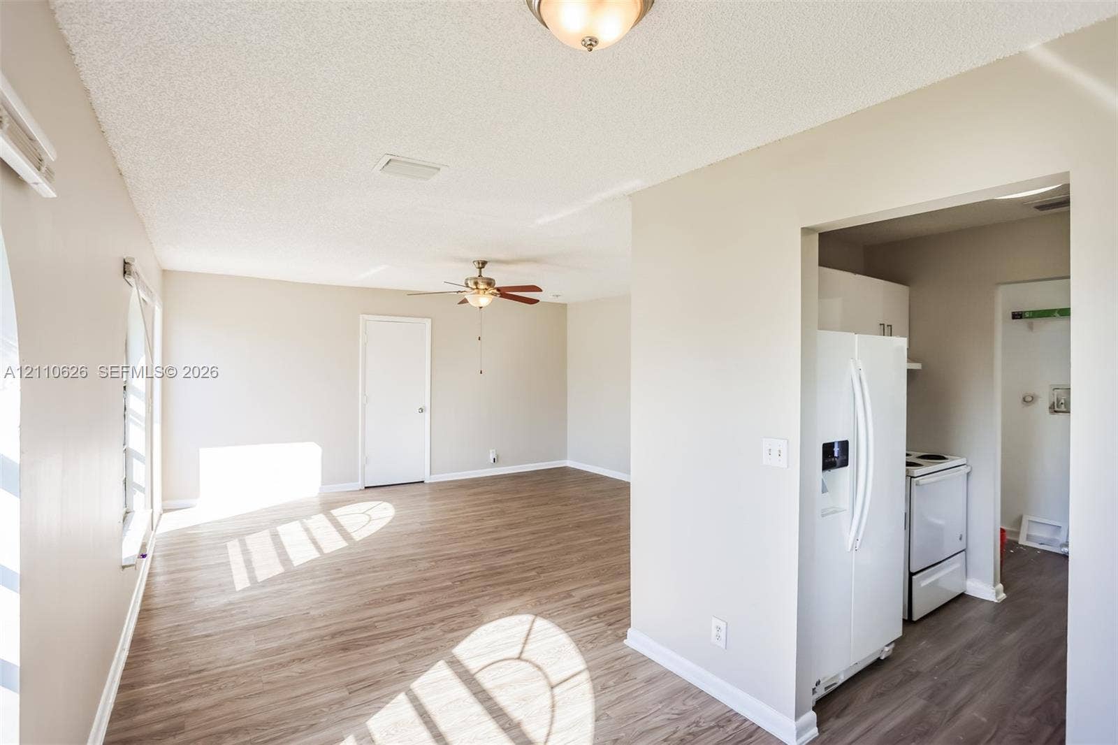 1301 NW 2nd Street, Dania, Dania Beach, FL 33004 Wood-finish flooring, neutral wall tones, ceiling fan with integrated lighting, and kitchen equipped with a white refrigerator and electric range
