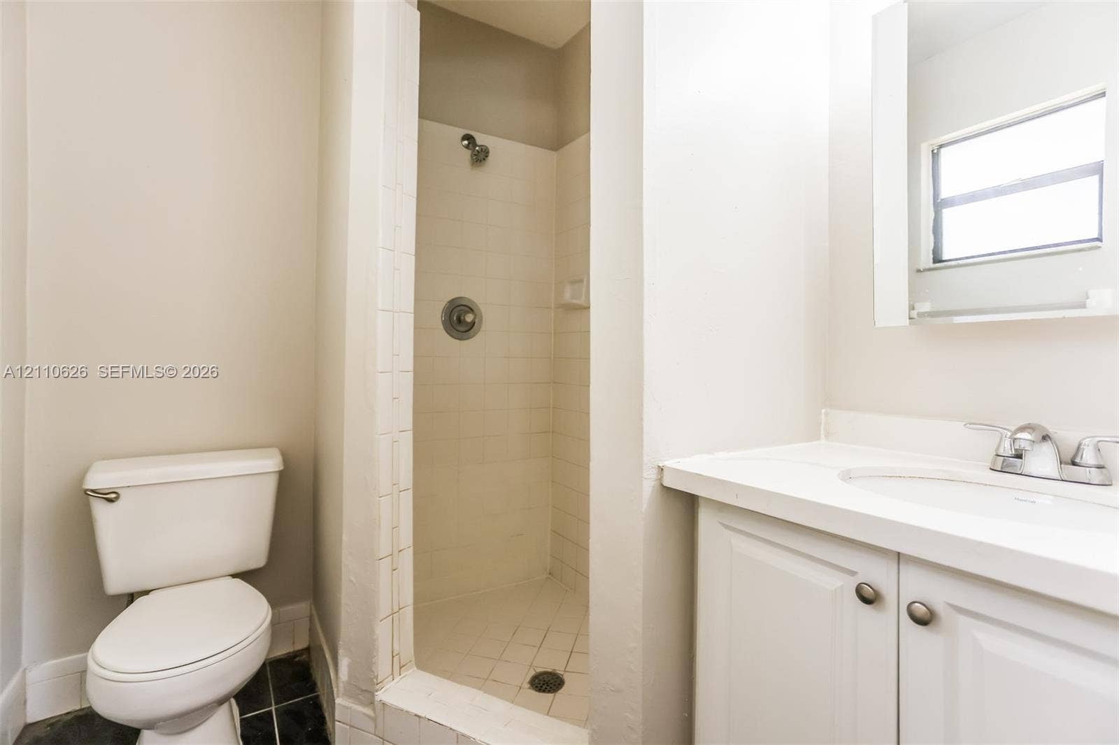 1301 NW 2nd Street, Dania, Dania Beach, FL 33004 Bathroom featuring a white vanity with an integrated sink, polished chrome faucet, tile-surround shower, and a window