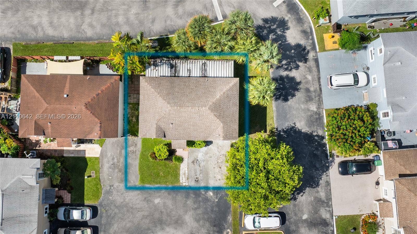 14732 SW 90th Terrace, Miami, FL 33196 Aerial perspective featuring a hip-roof structure, concrete driveway, and landscaped front lawn with mature palms